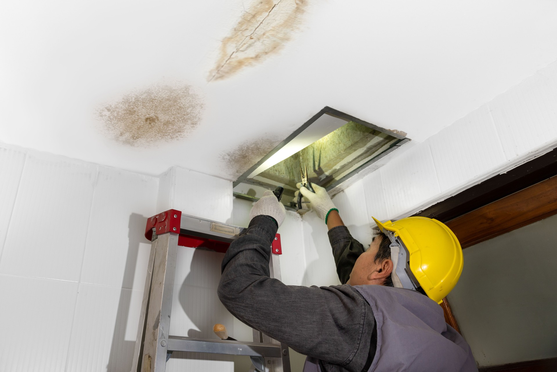Worker fix leaking pipe in ceiling ,close-up of a stain on the ceiling.